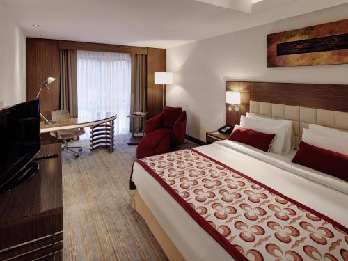 ein Hotelzimmer mit großem Bett und Schreibtisch in der Unterkunft Mercure Istanbul Altunizade in Istanbul