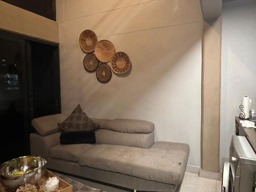 ein Wohnzimmer mit einer Couch und Tellern an der Wand in der Unterkunft The Onyx Black in Durban