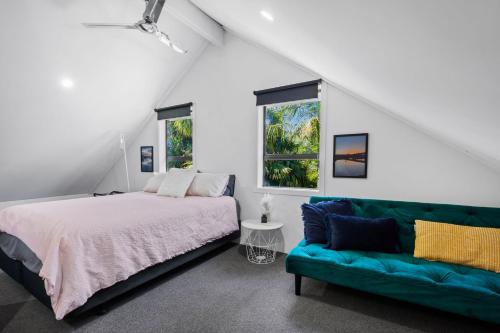 un dormitorio con una cama y un sofá en Self-contained Studio close to Kensington Park, en Whangarei