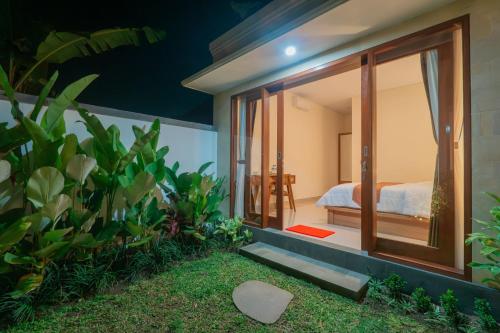 a room with a view of a bed and a garden at Adhy Villa Ubud by Bali Cabin in Ubud