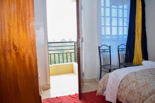 ein Schlafzimmer mit einem Bett und einem Balkon in der Unterkunft Manta Suites Air B&B in Thika