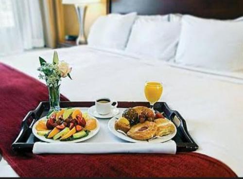 bandeja con dos platos de comida en una cama en Penthouse Bandarawela, en Bandarawela