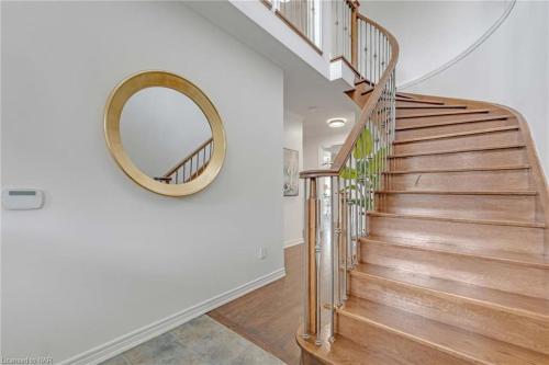 ein Treppenhaus mit einem runden Spiegel und einer Wendeltreppe in der Unterkunft Tranquil Haven near Niagara in Thorold