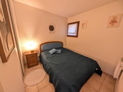 a small bedroom with a bed and a night stand at Confort pour 4, proche pistes, garage, balcon sud - FR-1-445-231 in Montgenèvre