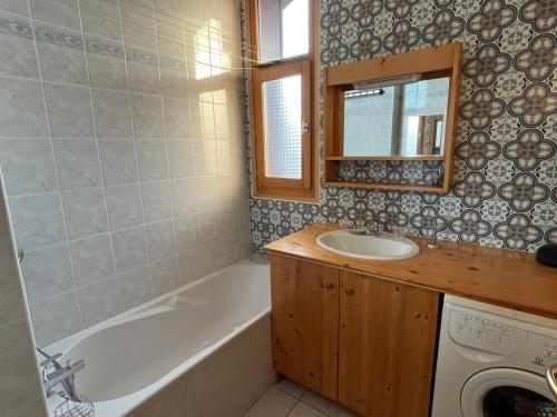 萨莫安斯Confortable T3 au cœur de Samoëns avec WIFI et parking - FR-1-629-152的带水槽、浴缸和镜子的浴室