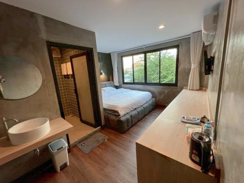a bathroom with a bed and a sink in a room at Wat We See Bangkok Hostel in Bangkok