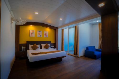 Un dormitorio con una cama grande y una silla azul. en Hotel White Flower, en Jāmb