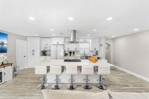 a kitchen with a large white island with bar stools at 332 Formosa Drive in Cocoa Beach
