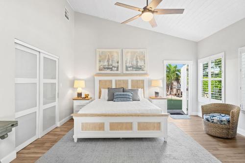 a white bedroom with a bed and a ceiling fan at 445 Watts Way in Cocoa Beach