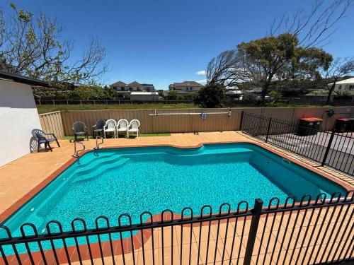 a small swimming pool with a fence around it at Heyfield Motel and Apartments in Lakes Entrance