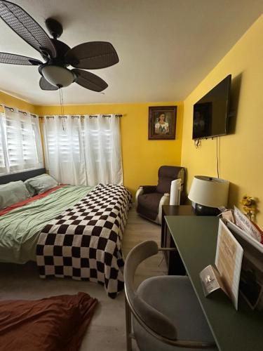 a bedroom with a bed and a ceiling fan at Yellow Cactus Oasis in White Water