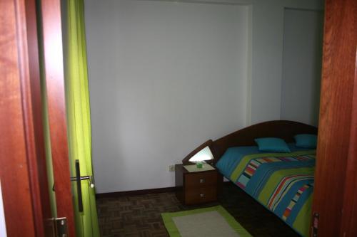 サン・マルティーニョ・ド・ポルトにあるApartamento Conde de Avelarの小さなベッドルーム(ベッド1台、ナイトスタンド付)