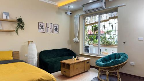 a bedroom with a bed and a chair and a window at Home Homestay in Hanoi