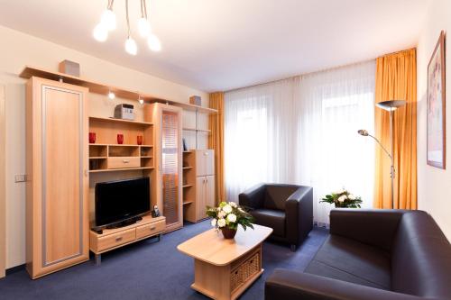 a living room with a couch and a television at Aparthotel Münzgasse An der Frauenkirche in Dresden