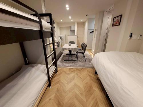 a room with two bunk beds and a table and chairs at ローズパーク十番館 in Narashino