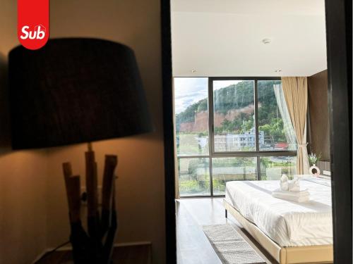 a bedroom with a bed and a large window at Modern Haven Suite in Hat Yai in Ban Thung Ngai