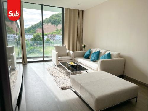 a living room with a couch and a table at Modern Haven Suite in Hat Yai in Ban Thung Ngai