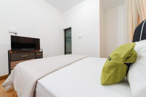 a bedroom with a white bed with a yellow pillow at Urbanview near Mall Botania 2 in Pulau Sembakau Besar