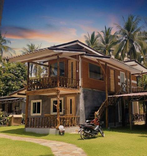 a house with a motorcycle parked in front of it at Dansontayakohlibong in Ko Libong Island