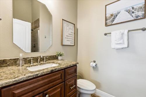 um banheiro com uma pia, um vaso sanitário e um espelho em Cape Crossing 103 em Merritt Island