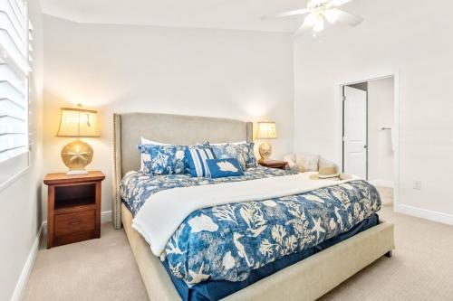 a bedroom with a blue and white bed and a window at Cape Crossing 104 in Merritt Island
