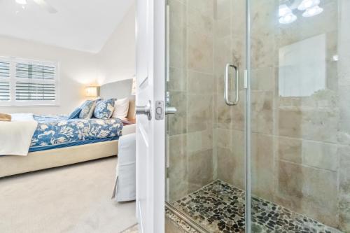 a bathroom with a shower and a bed in a room at Cape Crossing 104 in Merritt Island