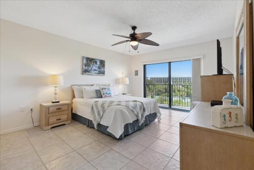 een slaapkamer met een bed en een plafondventilator bij Windrush 509 in Cocoa Beach