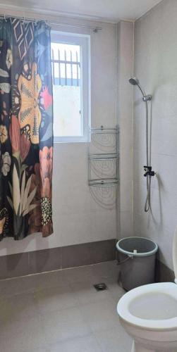 a bathroom with a shower curtain and a toilet at Beach Side Cabin San Juan ELYU in San Juan