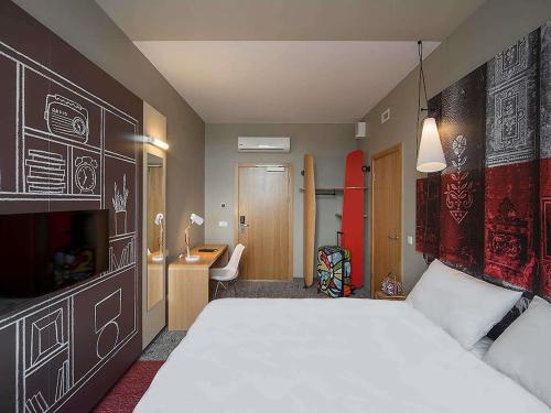 a bedroom with a large white bed and a desk at Ibis Riga Centre in Rīga