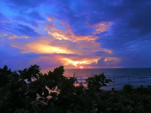 a sunset on the beach with the ocean at Beach Side Cabin San Juan ELYU in San Juan