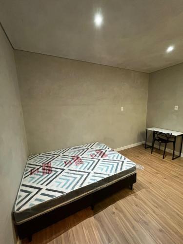 a bed in a room with a table in it at Carneiro Hotel in Itatiba