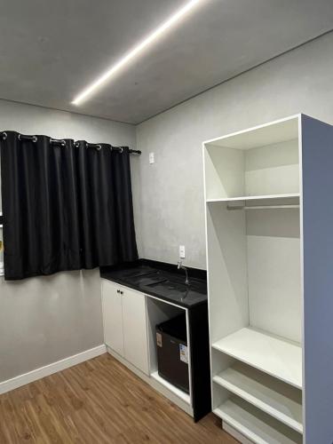 an empty room with a black curtain and a closet at Carneiro Hotel in Itatiba