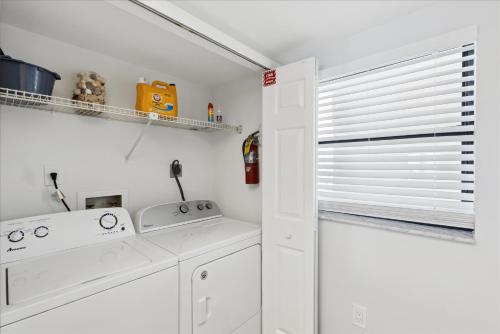 une cuisine avec des appareils blancs et une fenêtre avec des stores dans l'établissement Boardwalk 401, à Cocoa Beach