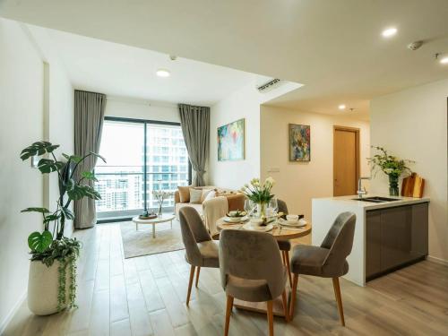 ein Wohnzimmer mit Tisch und Stühlen und eine Küche in der Unterkunft Apec Boutique Hotel Phú Yên in Phước Hậu (1)