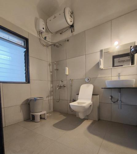 a bathroom with a toilet and a sink at Golden Maple Villa in Jāmb