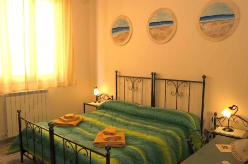 a bedroom with a green bed with two towels on it at I Colori Del Sole in Fiumefreddo di Sicilia