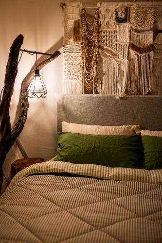 a bedroom with a bed with green pillows and a lamp at Bluff Getaway Flinders Island Tasmania in Whitemark
