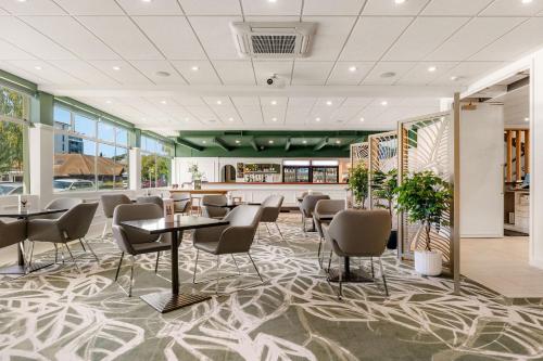 a restaurant with chairs and tables in a room at Hotel Armitage and Conference Centre in Tauranga