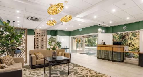 an office lobby with green walls and a table at Mercure Tauranga in Tauranga