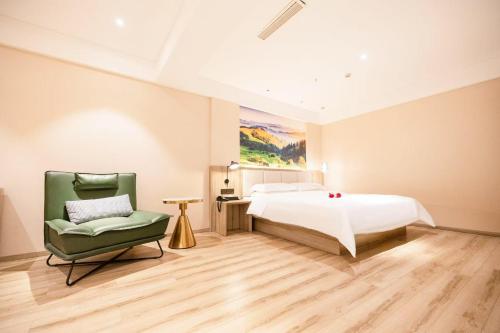 Un dormitorio con una cama grande y una silla en Qingdao Likelai Garden Hotel, en Qingdao