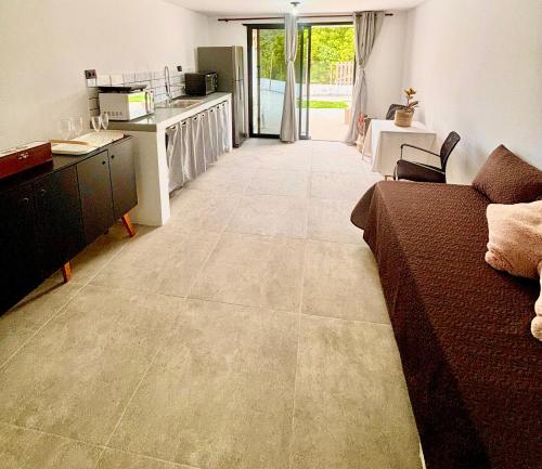 een woonkamer met een bank en een keuken bij Refúgio Urbano in Jacareí