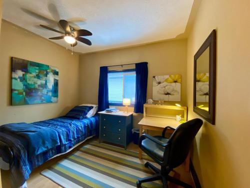 a bedroom with a bed and a desk and a chair at Spacious & Practical 4 Bed Home in Sudbury