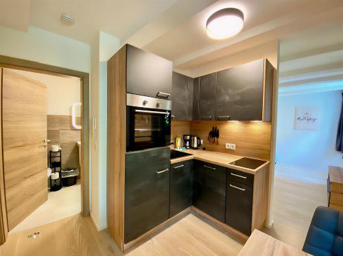 - une cuisine avec des armoires noires et un réfrigérateur noir dans l'établissement Modern Old Town Studio, à Hall en Tirol