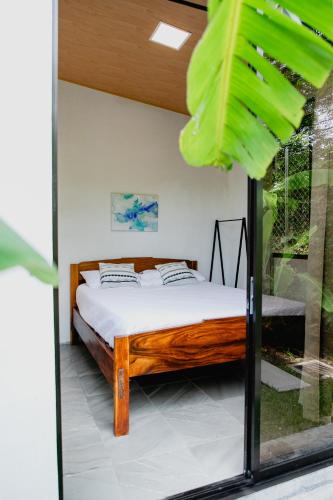 a bedroom with a bed in a room with a window at Villa Palmarcito in El Zonte