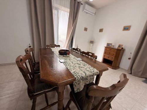 a wooden table in a room with chairs and a tableablish at Ta Mary Apartment A Perfect St Pauls Bay Base in St Paul's Bay