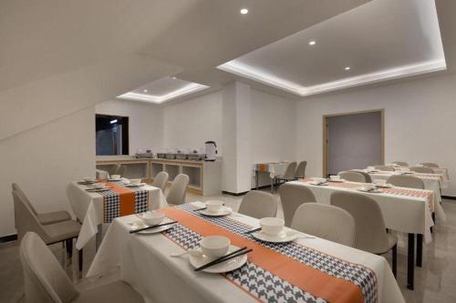 a large room with tables and chairs and a kitchen at JTOUR Inn Wuhan Wusheng Road Metro CapitaLand Plaza in Wuhan