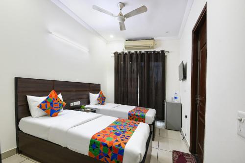 古尔冈Hotel Springbok的一间带两张床和吊扇的卧室