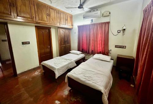 ein Krankenzimmer mit zwei Betten und einem Fenster in der Unterkunft Indeevaram in Kochi