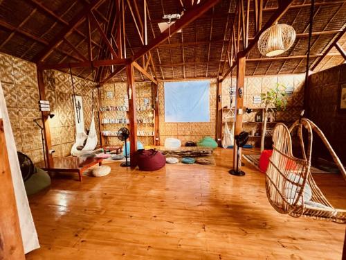 a large room with wooden floors and a large window at Nautilus Hostel & Hammocks in Panglao Island