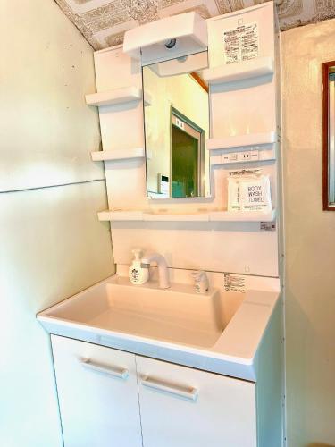 a bathroom with a sink and a mirror at okinawa海宿は海まで徒歩15歩の1棟貸でBBQ可能 in Nakijin